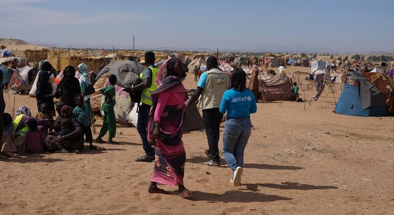 联合国儿童基金会的一名员工穿过苏丹难民营.